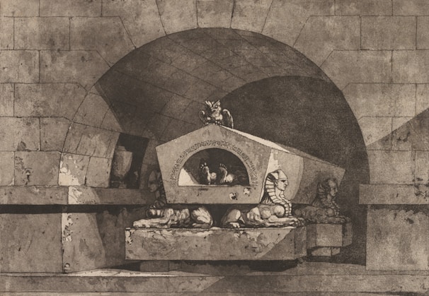 An ancient stone structure with a large archway and intricate carvings. The centerpiece is a sarcophagus-like monument adorned with two sphinx statues lying on either side. The setting appears to be underground or within a tomb, with shadowy areas suggesting depth and mystery.