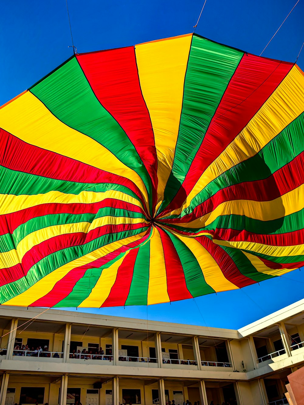 a large multicolored umbrella hanging in front of a building