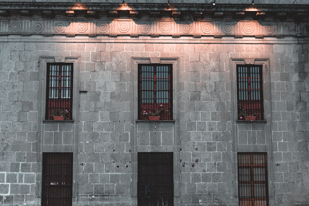 a building with three windows and a clock on the side of it