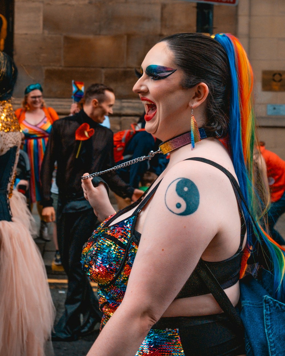 a woman in a colorful outfit with a yin sign painted on her chest