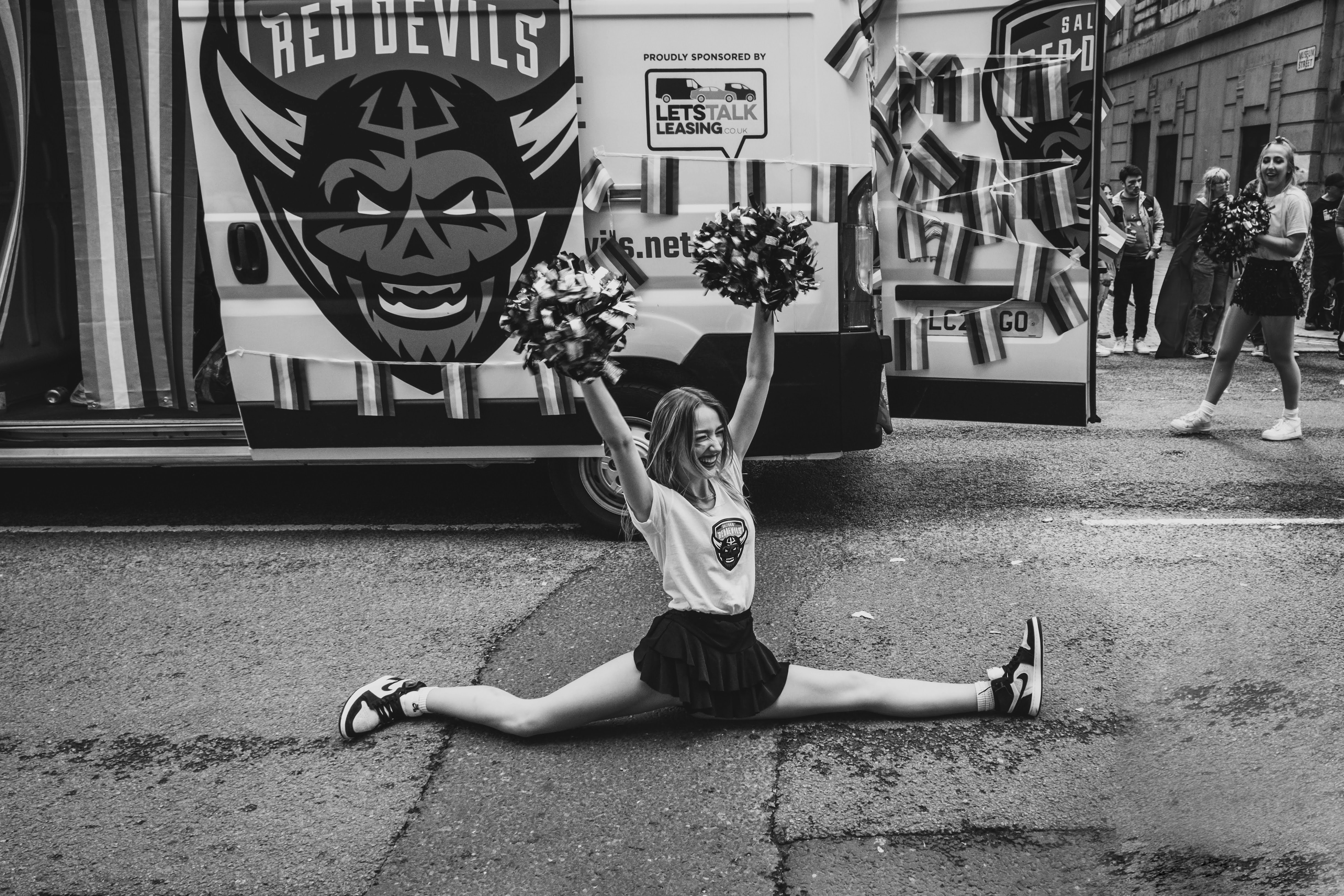 a woman sitting on the ground with a bunch of cheerleaders
