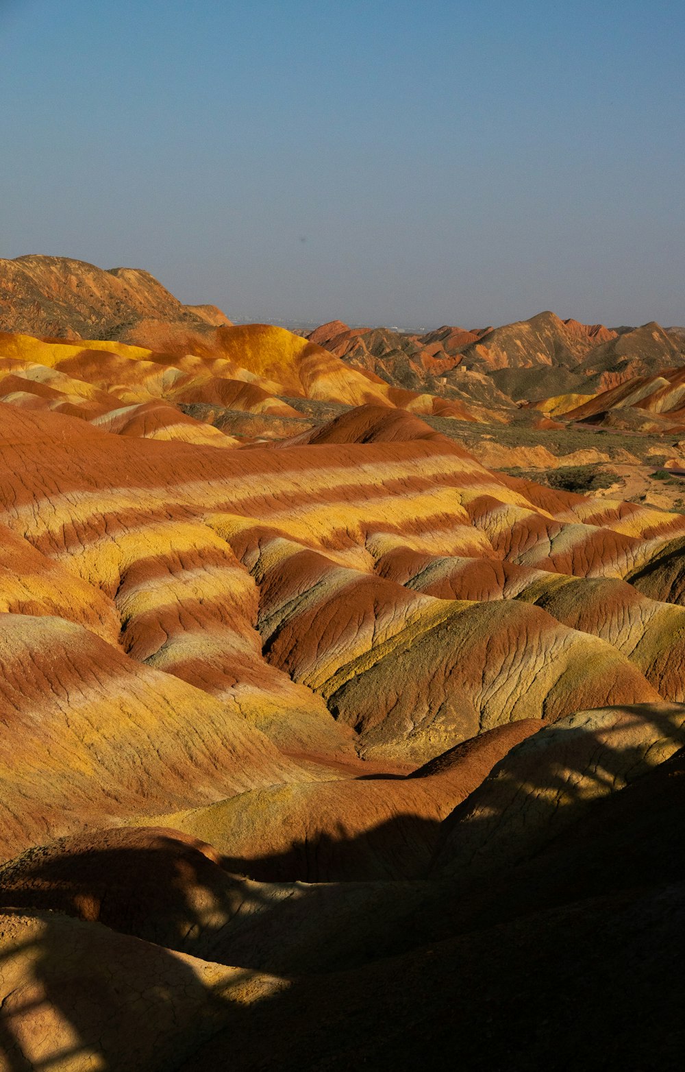 a view of a valley with yellow and brown hills in the background