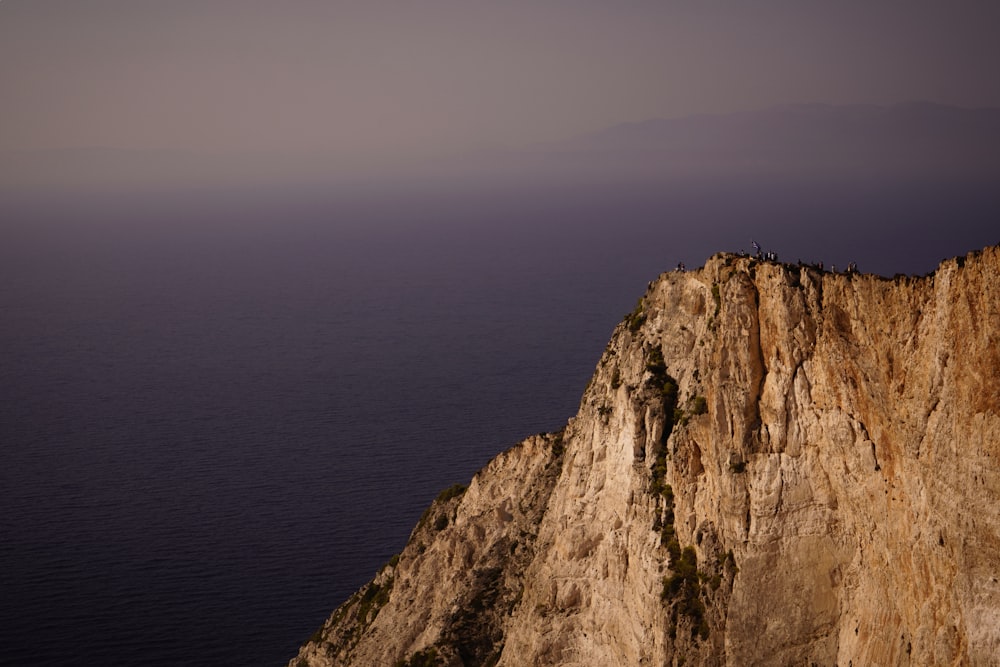 a cliff with a person standing on top of it