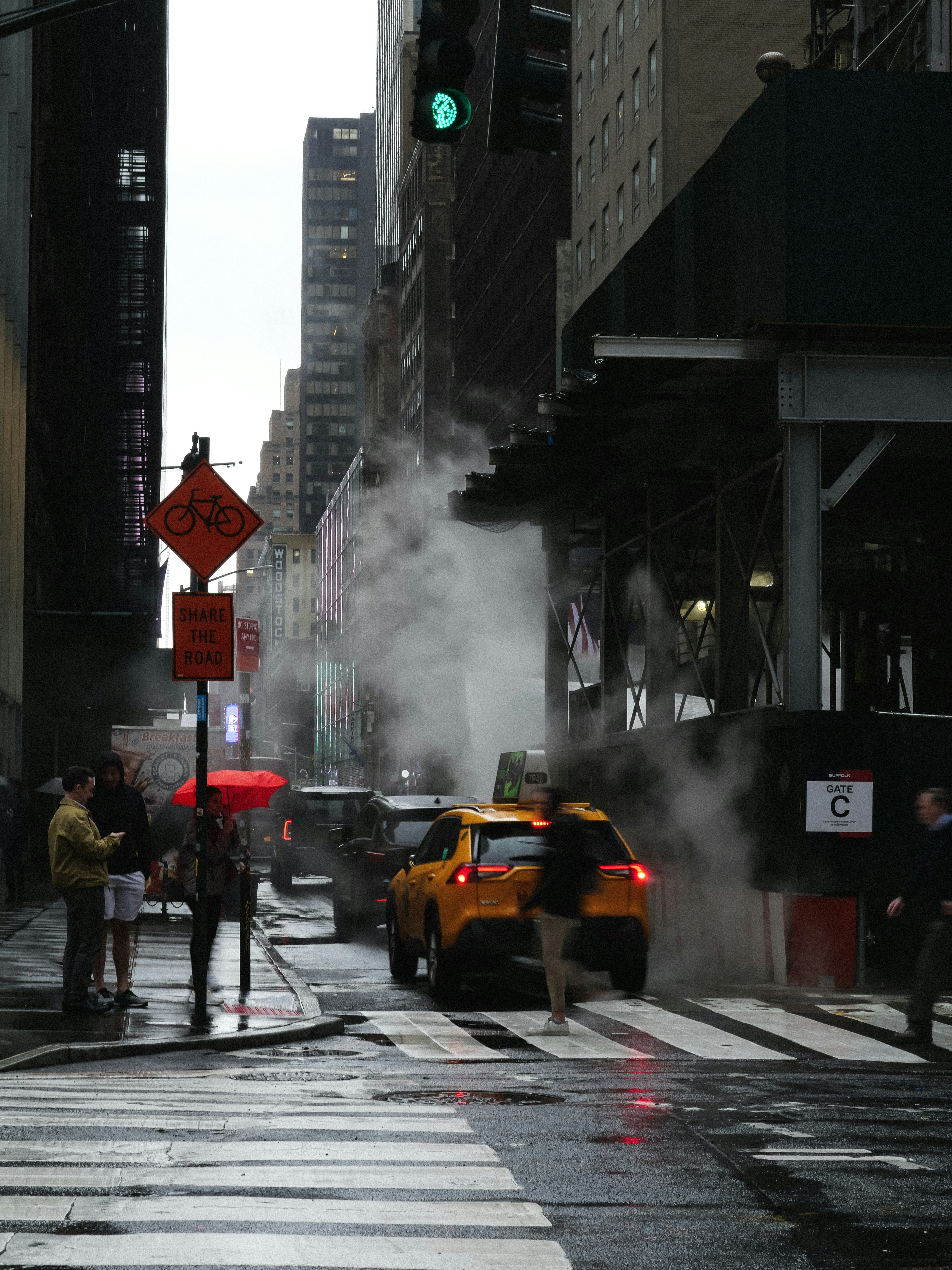 a yellow taxi driving down a street next to tall buildings