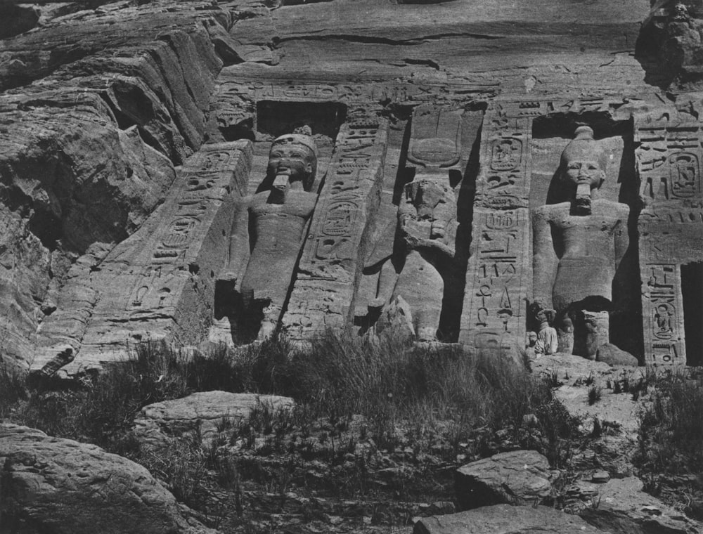 a black and white photo of egyptian statues