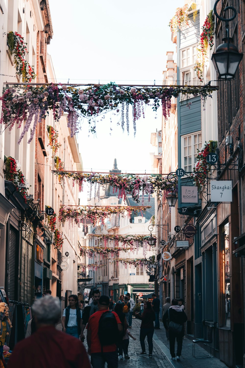 um grupo de pessoas andando por uma rua ao lado de edifícios altos