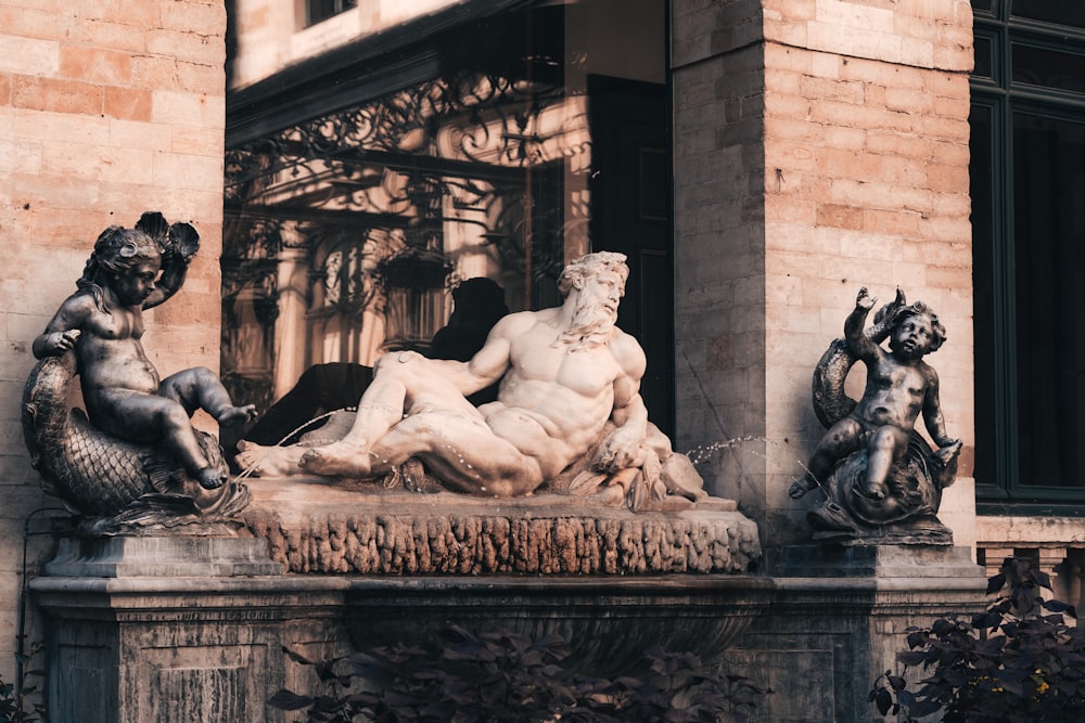 una statua di un uomo seduto in cima a una fontana