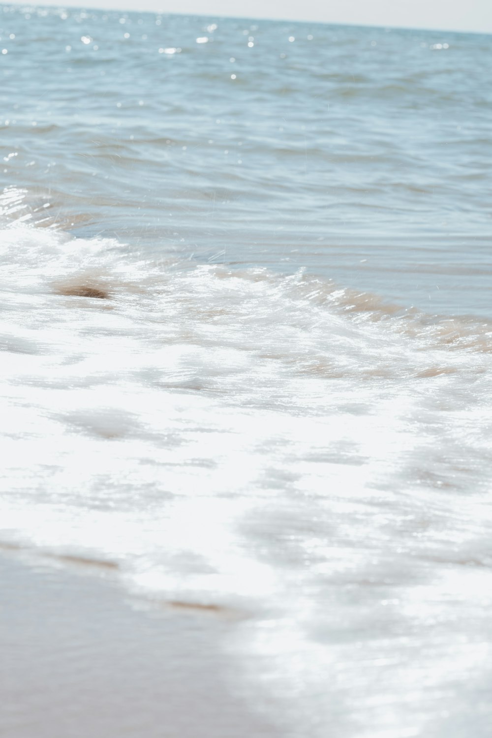 a person walking on the beach with a surfboard