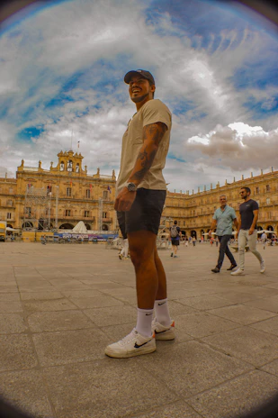 A casual scene showing a person wearing a Verdad Viva cap and t-shirt, standing confidently on a city street.