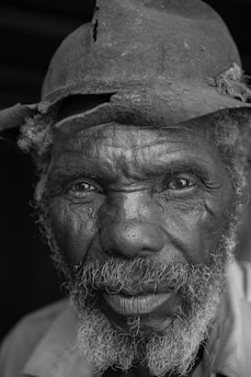 a black and white photo of a man wearing a hat
