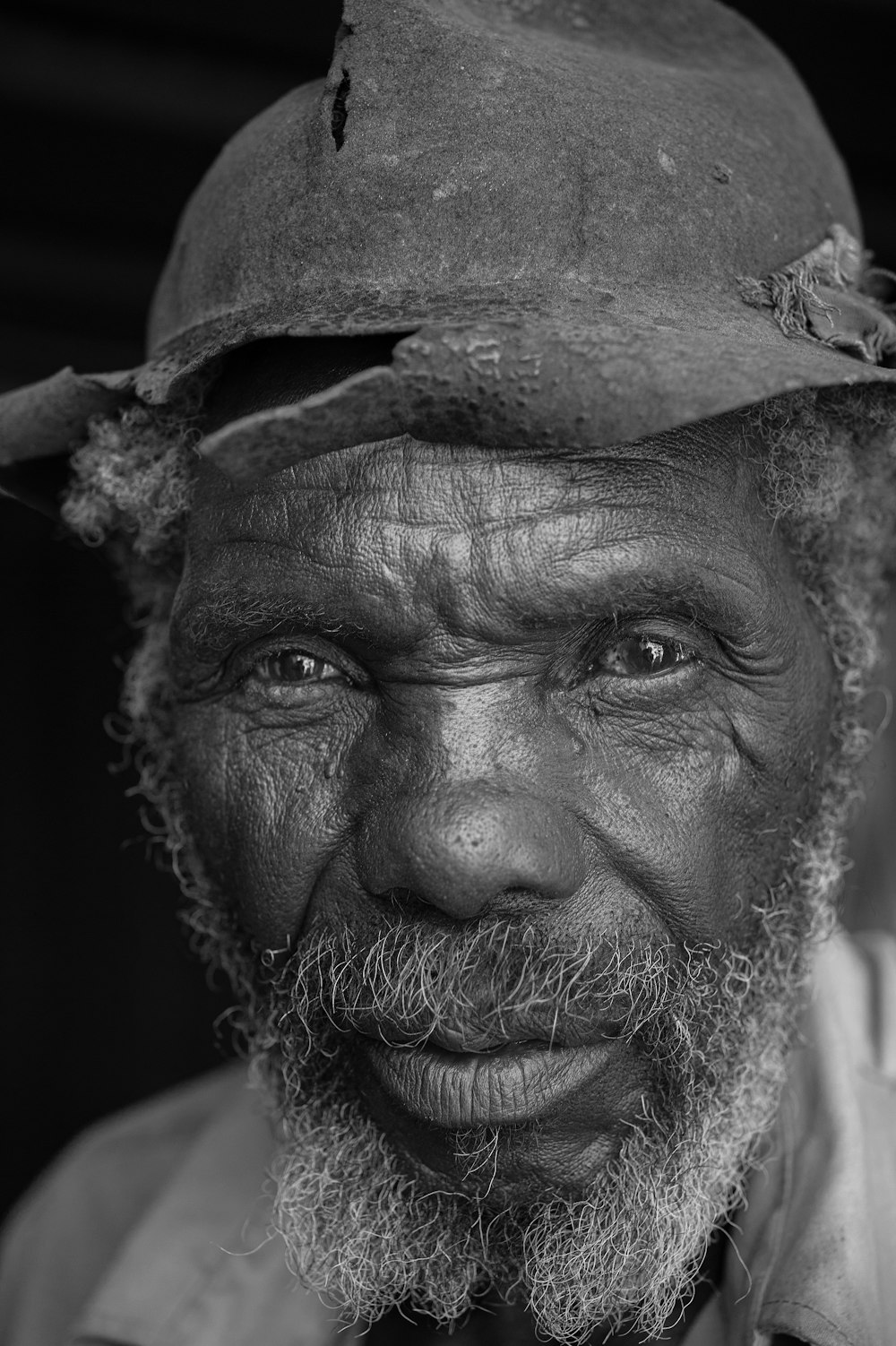 a black and white photo of a man wearing a hat