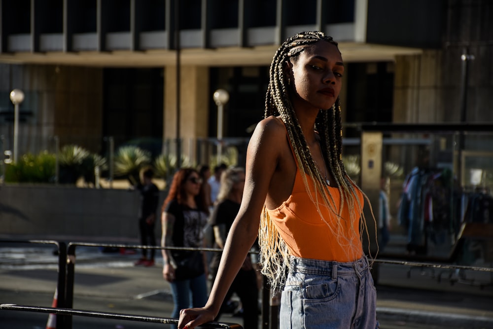 a woman with dreadlocks standing in front of a building