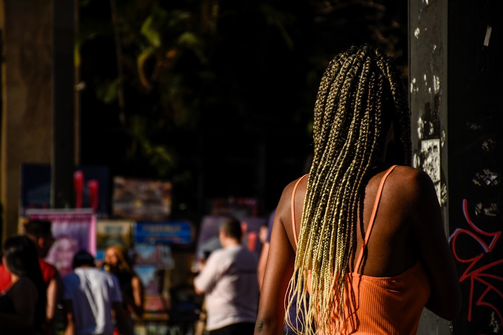 a woman with braids walking down a street