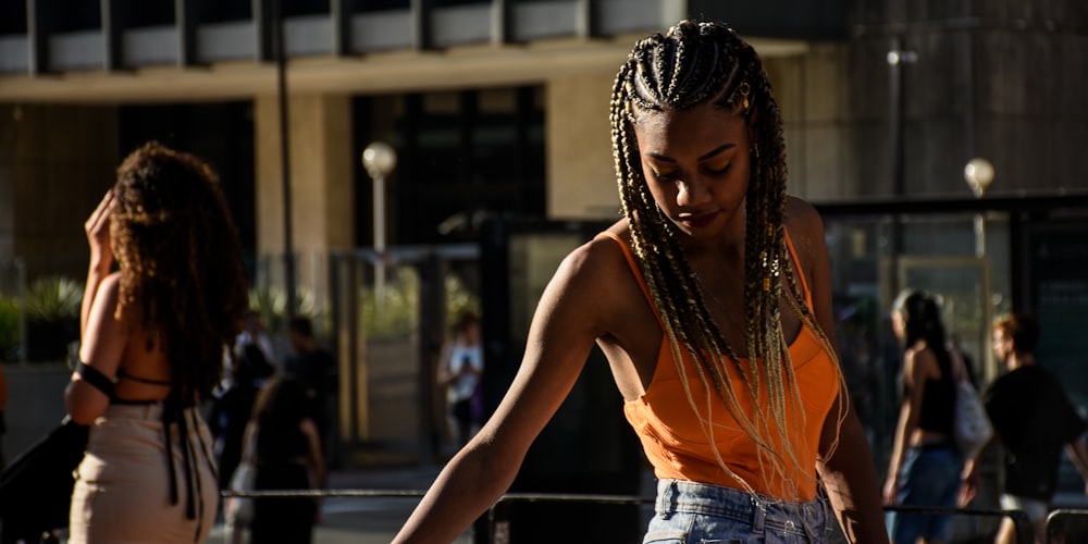 a woman with braids walking down a street