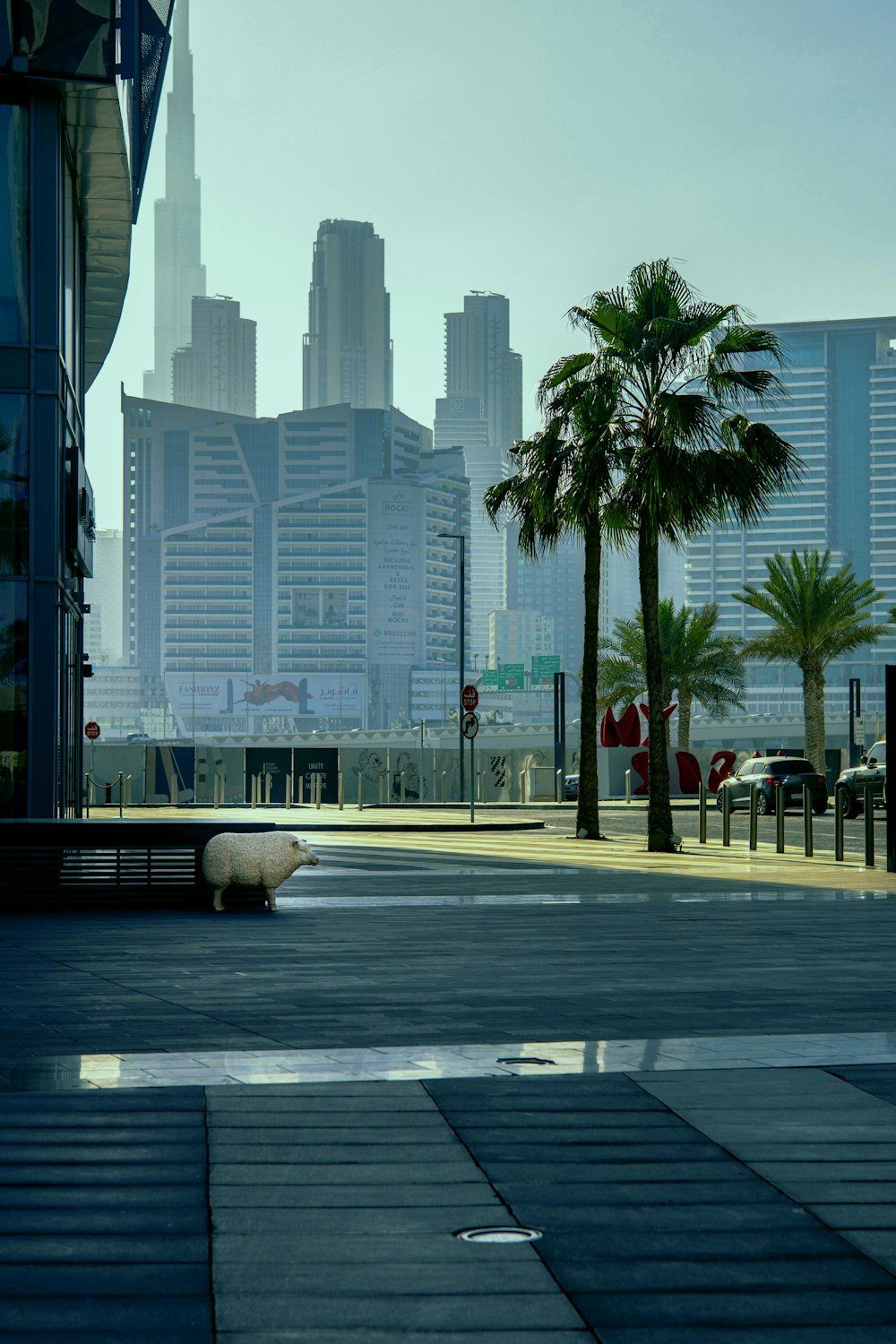 a city street with palm trees and buildings in the background