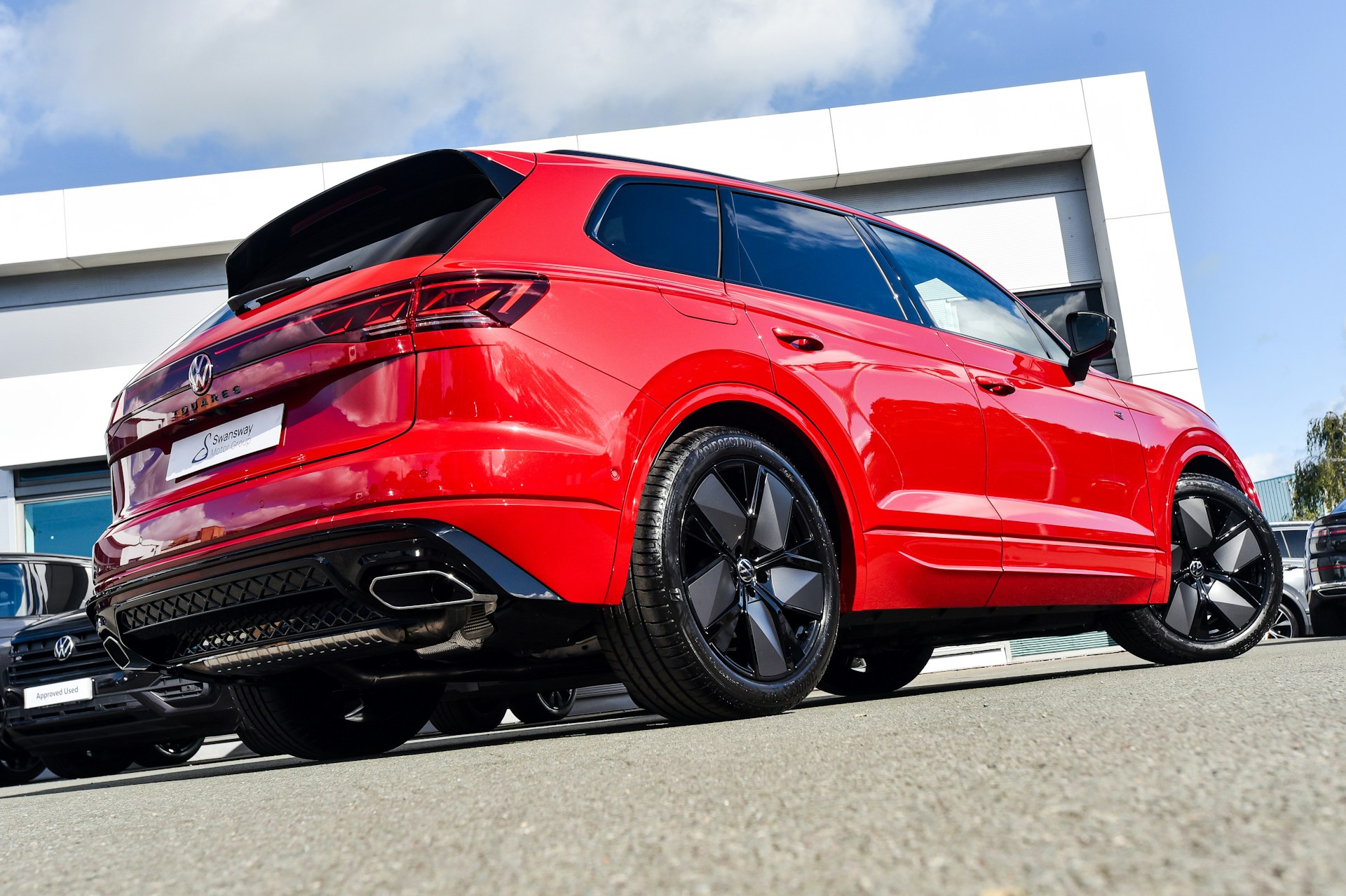 A vibrant red compact SUV showcased against a modern urban backdrop, highlighting its shiny finish and stylish design.
