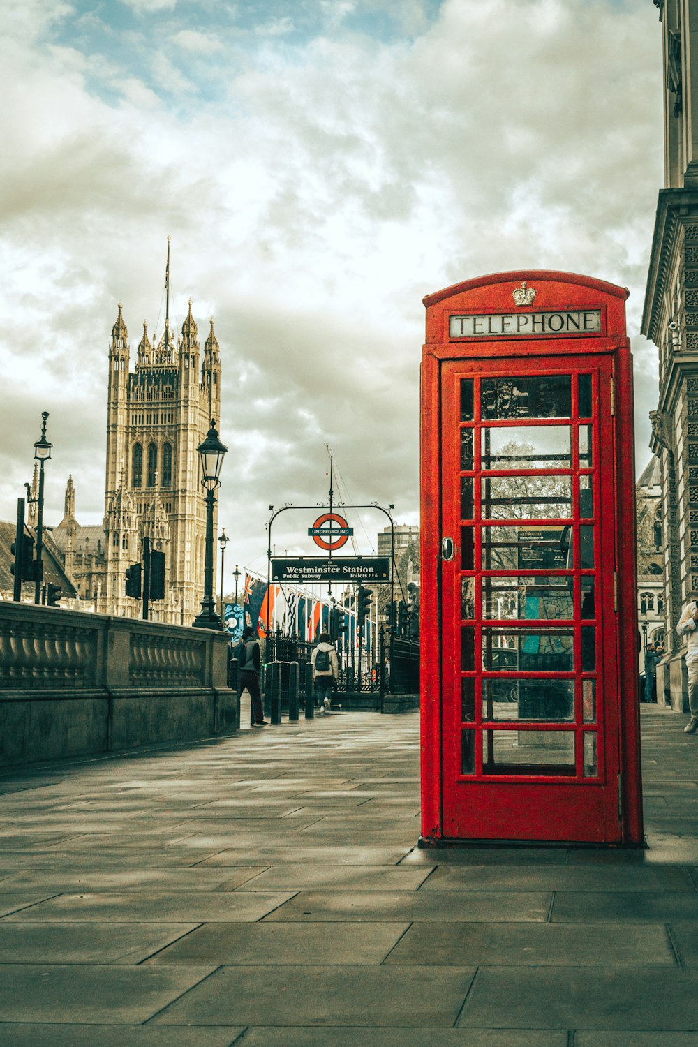 a red phone booth sitting on the side of a road