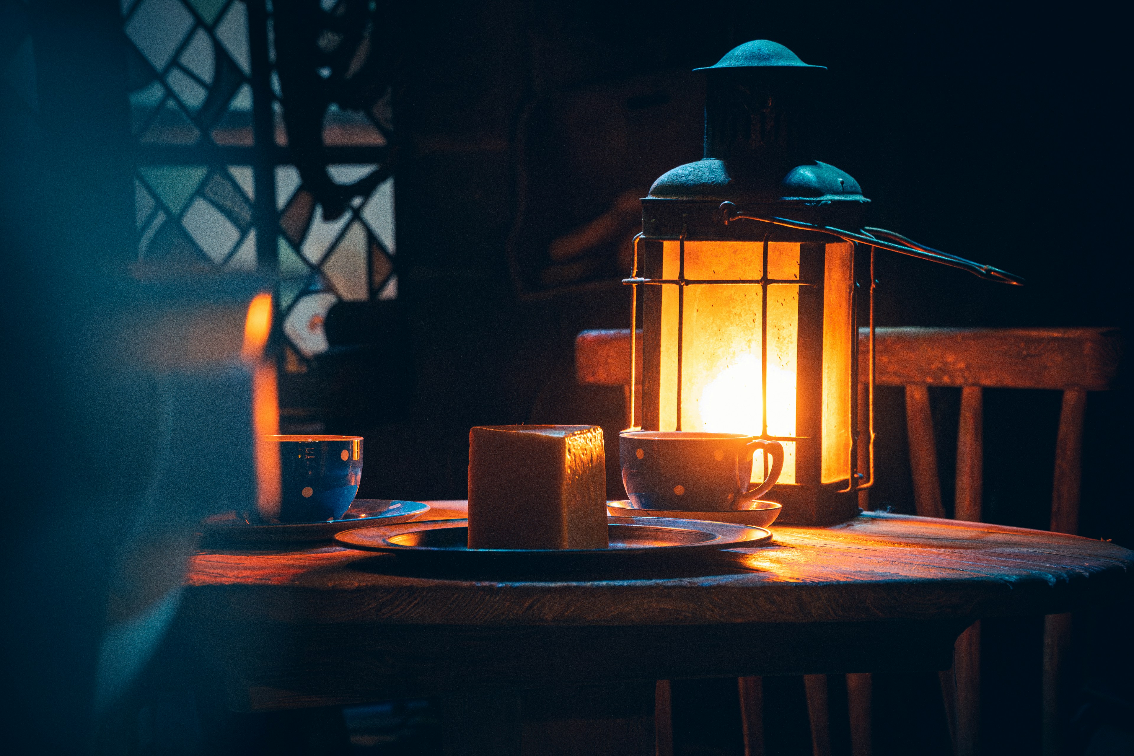 a lit lantern sitting on top of a wooden table