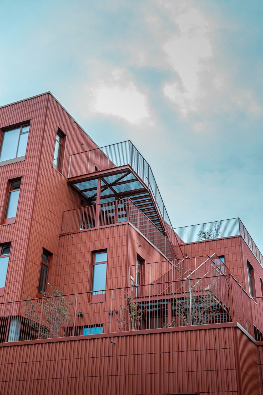 Un edificio rojo con una escalera que sube por el costado