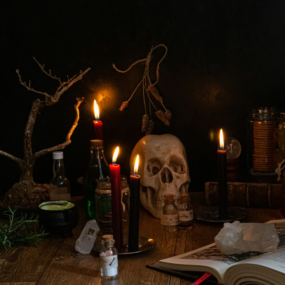 a wooden table topped with candles and skulls