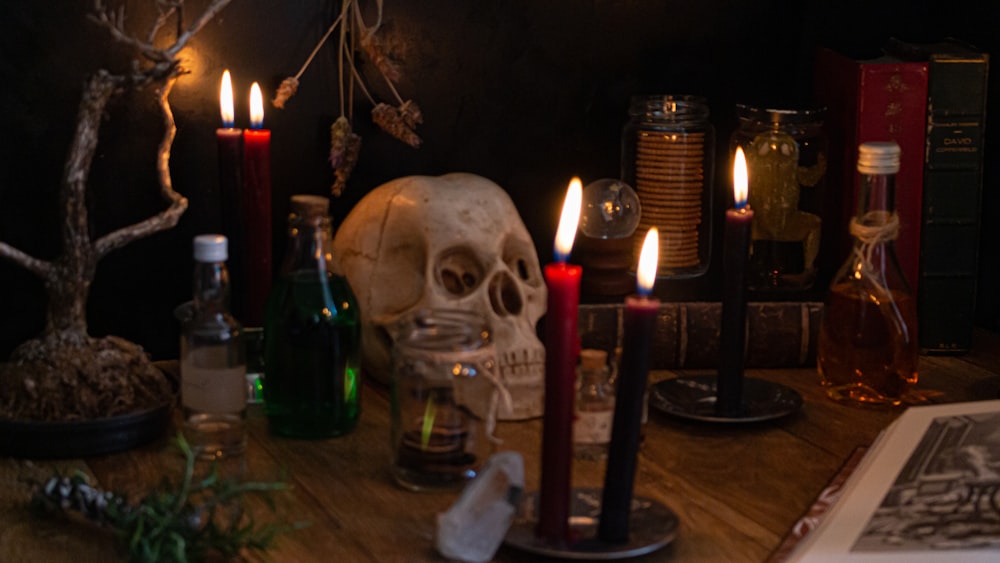a table topped with candles and a skull