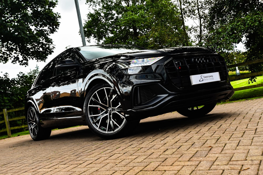 a black car parked on a brick road