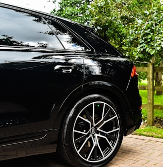 a black car parked on a brick driveway