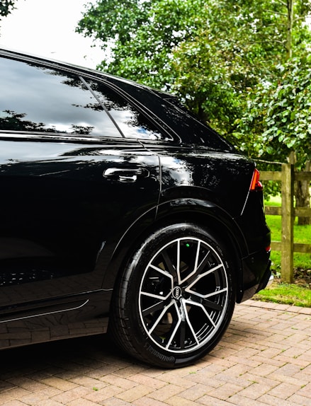 a black car parked on a brick driveway