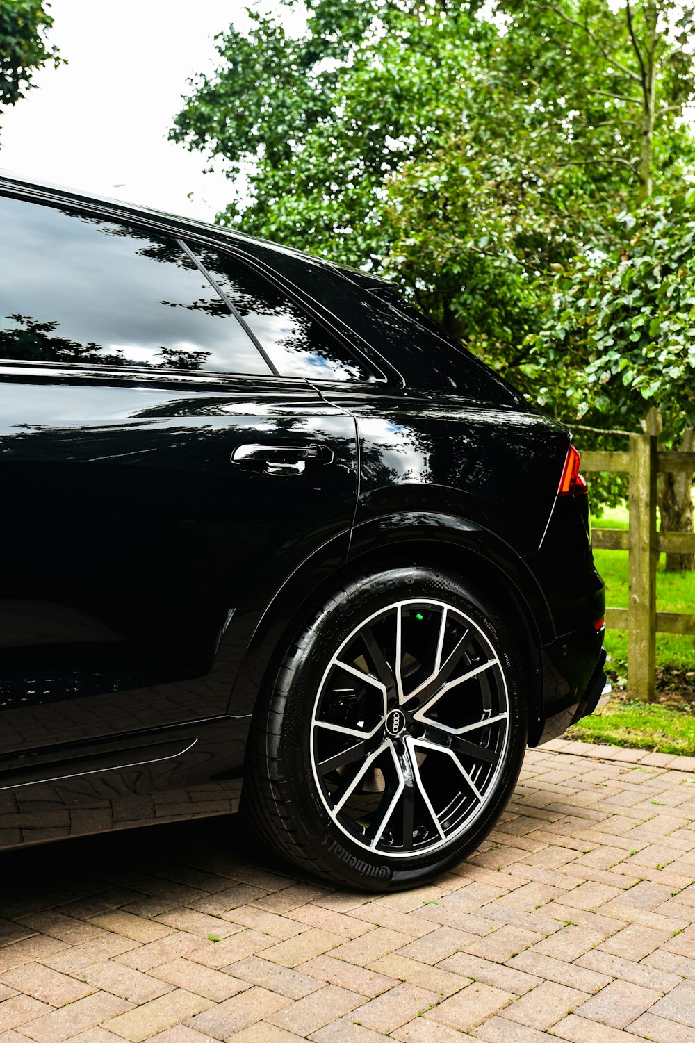 a black car parked on a brick driveway