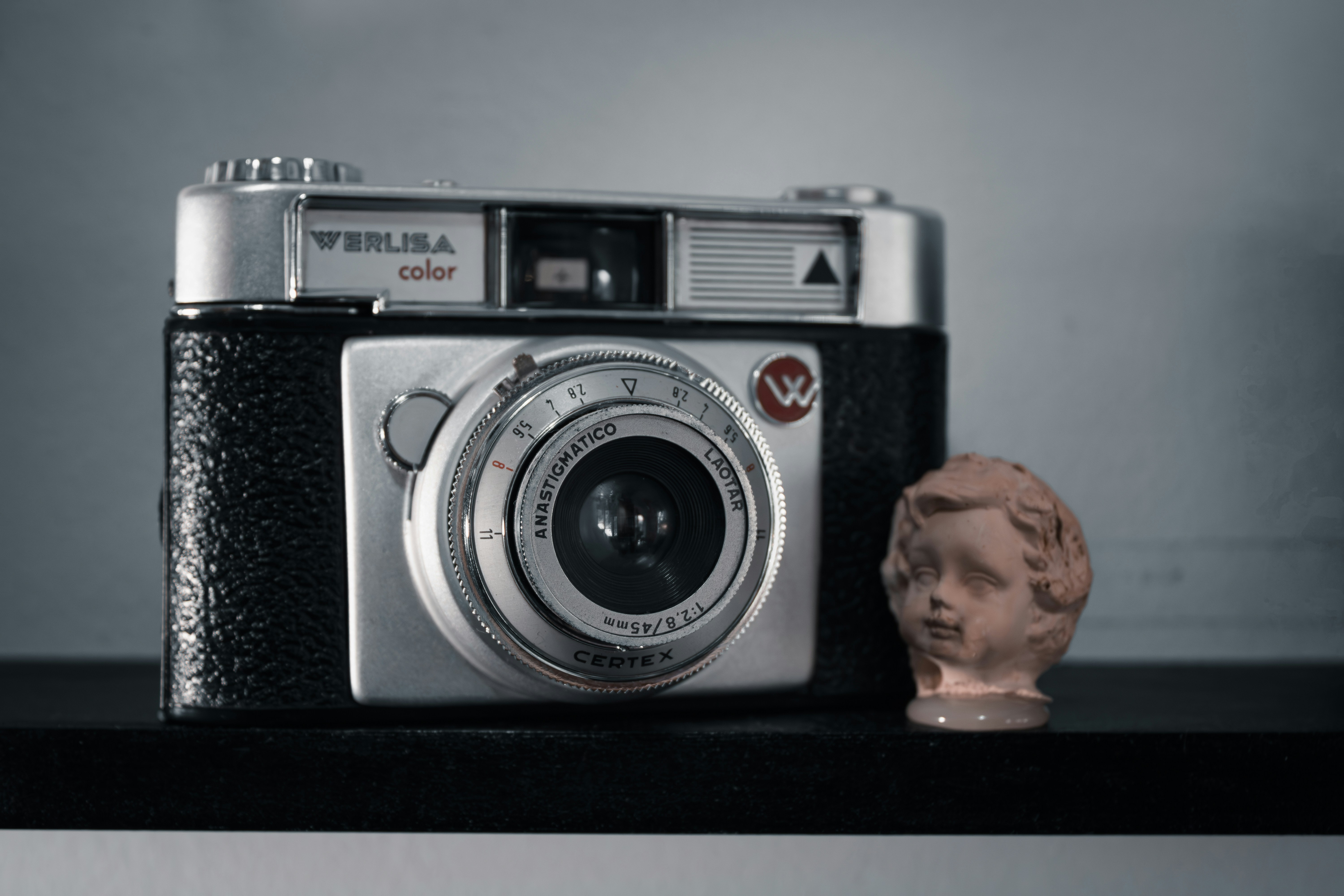 a camera and a busturine on a shelf