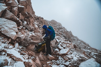 A hiker wearing a lightweight, breathable waterproof jacket with an adjustable hood, standing on a misty mountain trail.