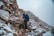 A hiker wearing durable outdoor clothing on a scenic mountain trail.