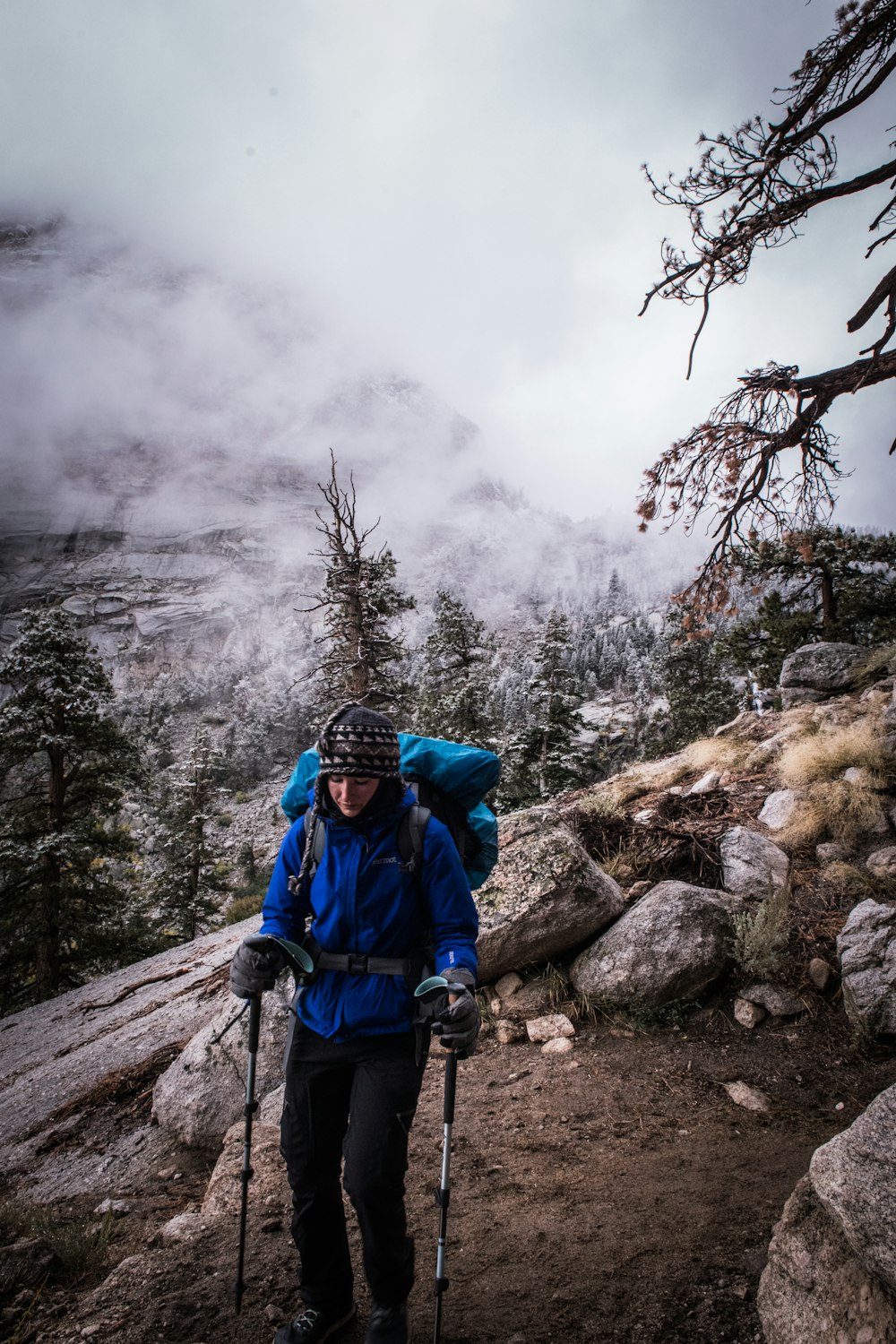 a man with a backpack and skis on a trail