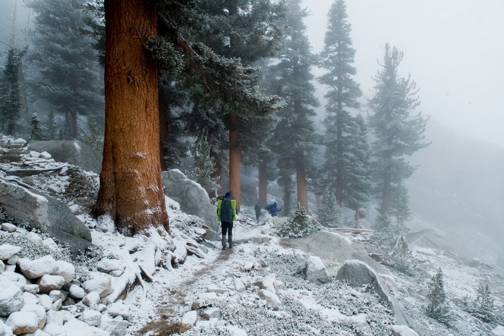 a man walking up a snow covered mountain trail