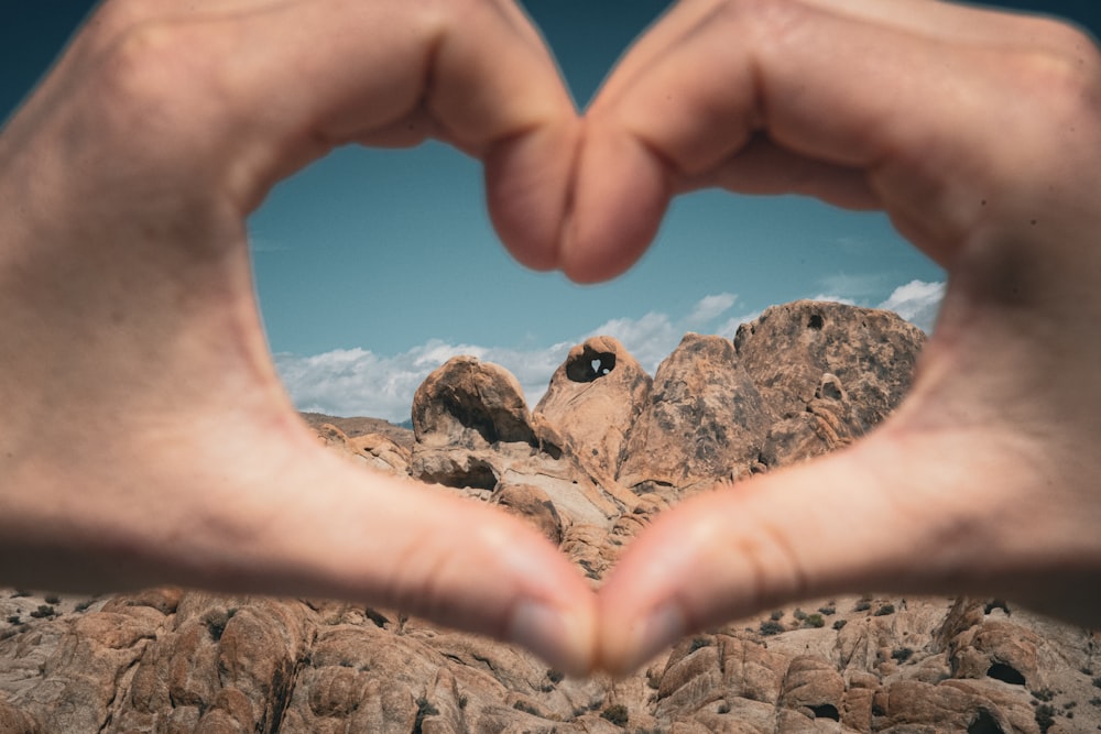 a person making a heart shape with their hands