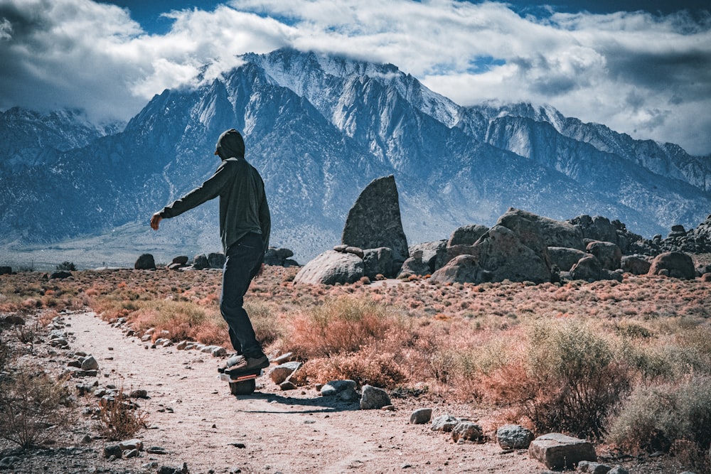 a man riding a skateboard down a dirt road