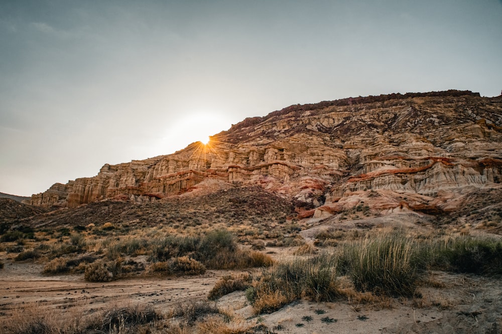 the sun is setting behind a rocky outcropping