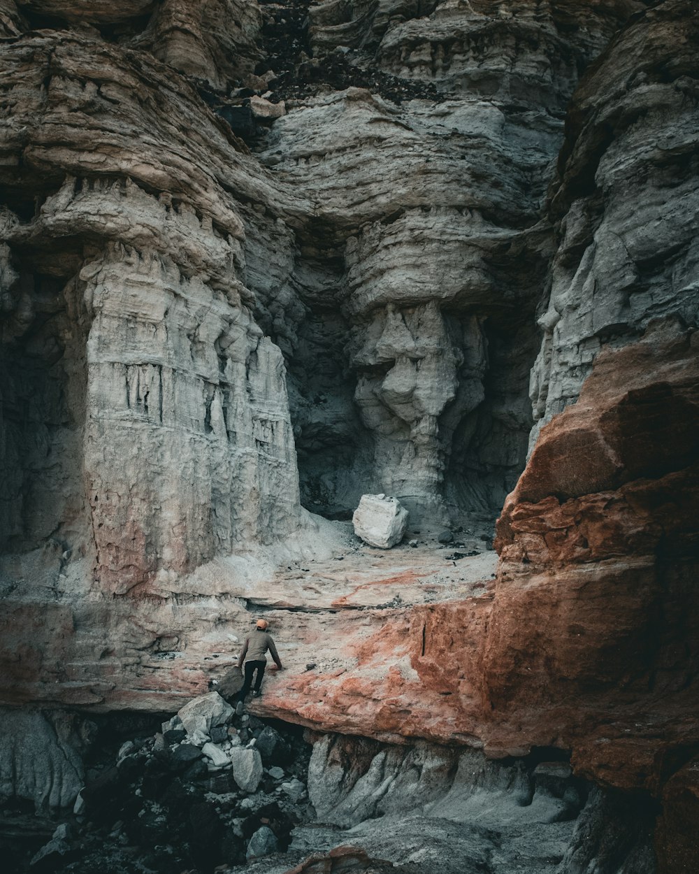 a man standing in a cave next to a mountain