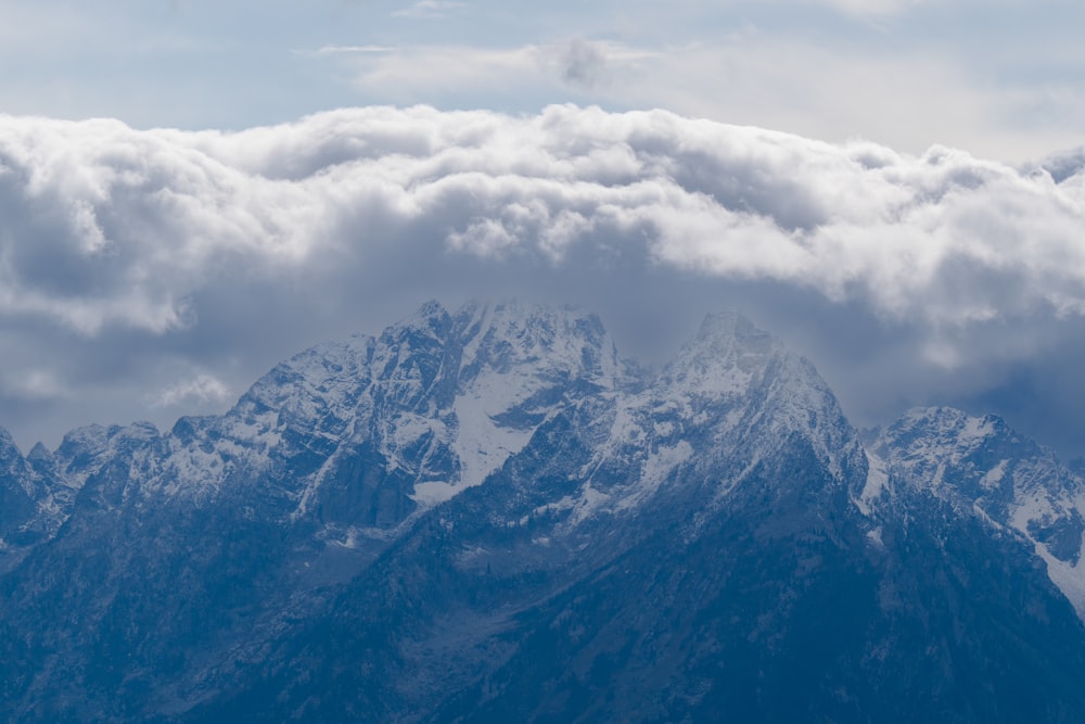 a view of the top of a mountain covered in clouds