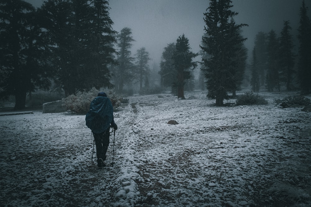 a person walking through a snow covered field