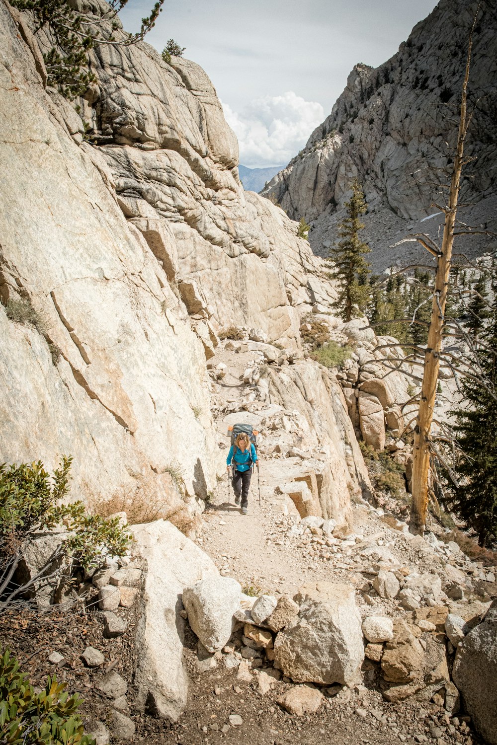 a person hiking up a rocky trail in the mountains