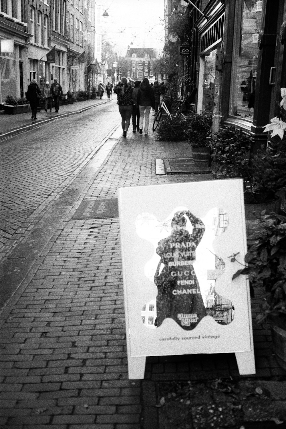 a black and white photo of a sign on a sidewalk