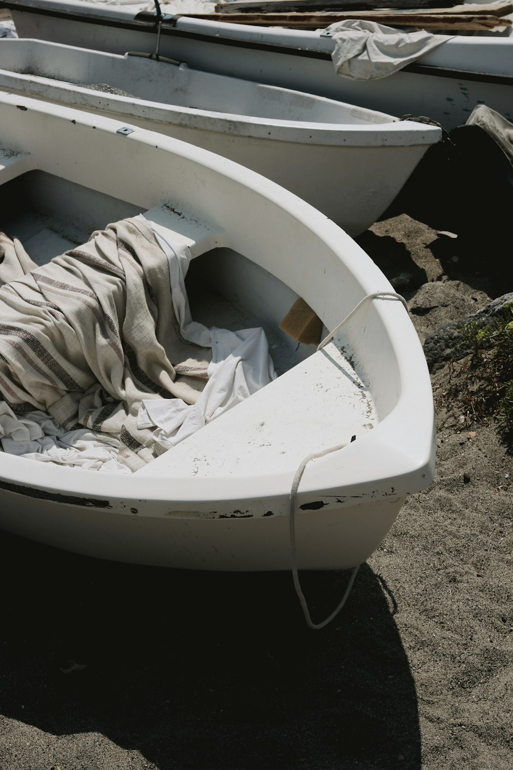 a couple of white boats sitting on top of a sandy beach