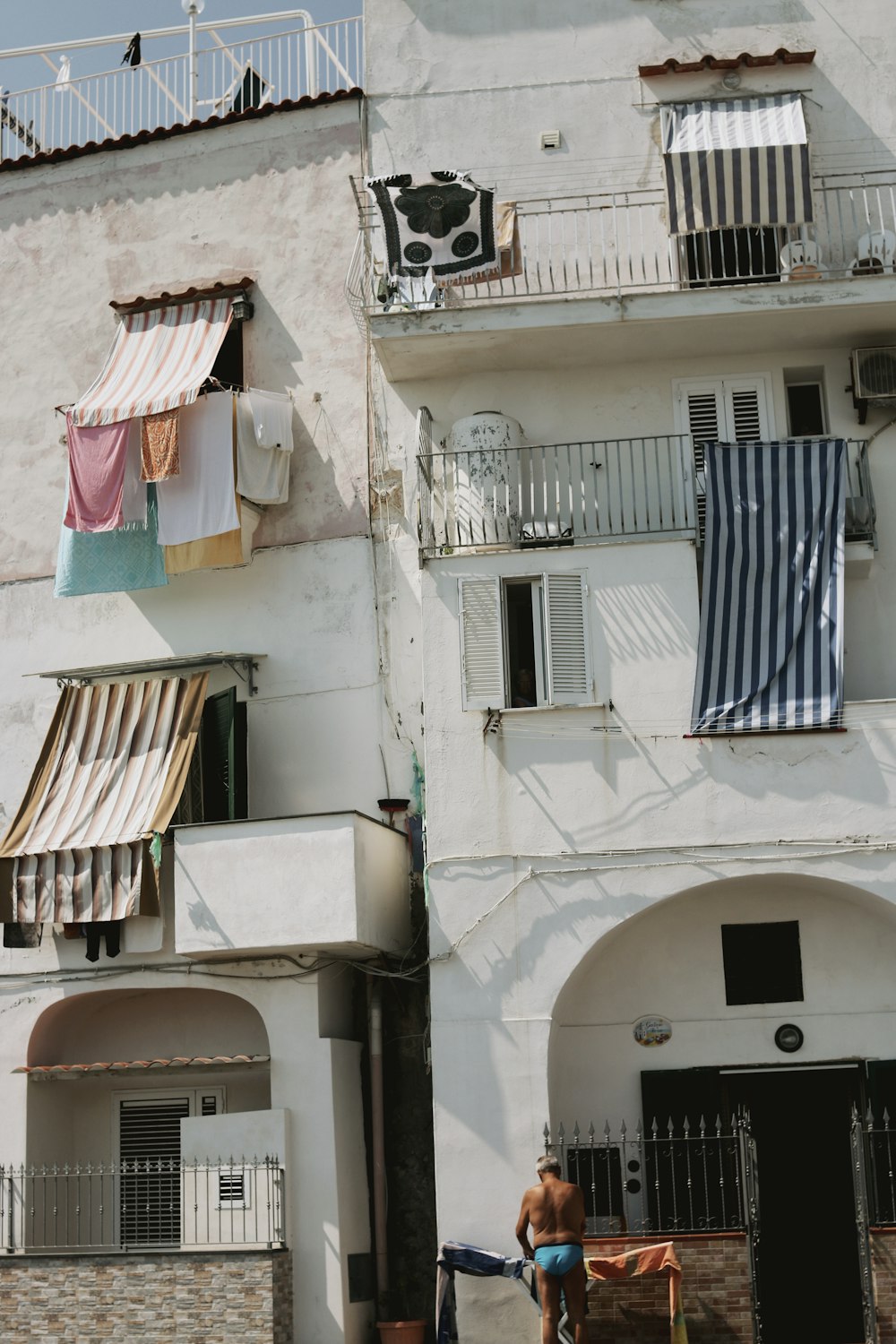 a man riding a bike past a tall white building