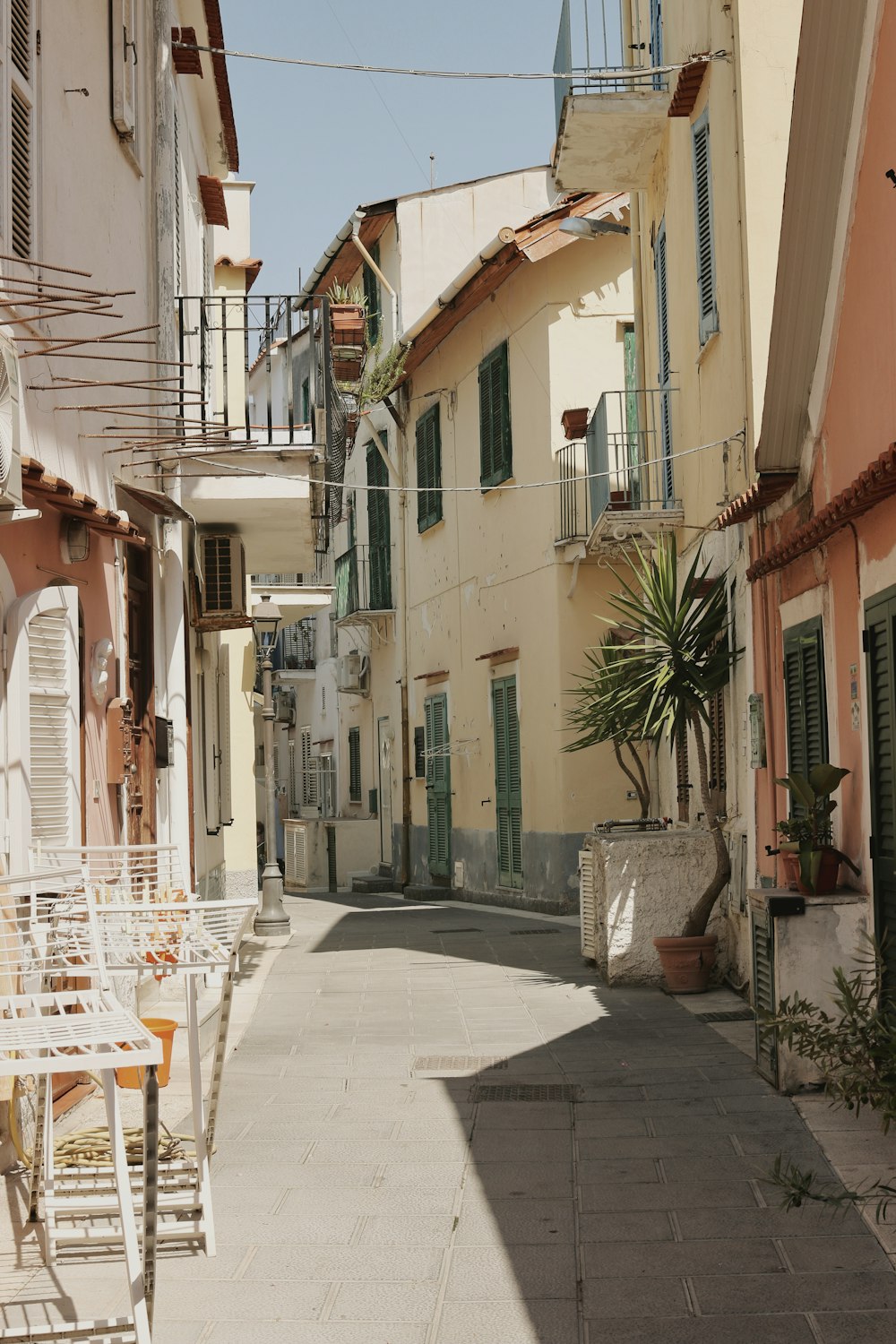 a narrow street with tables and chairs on it