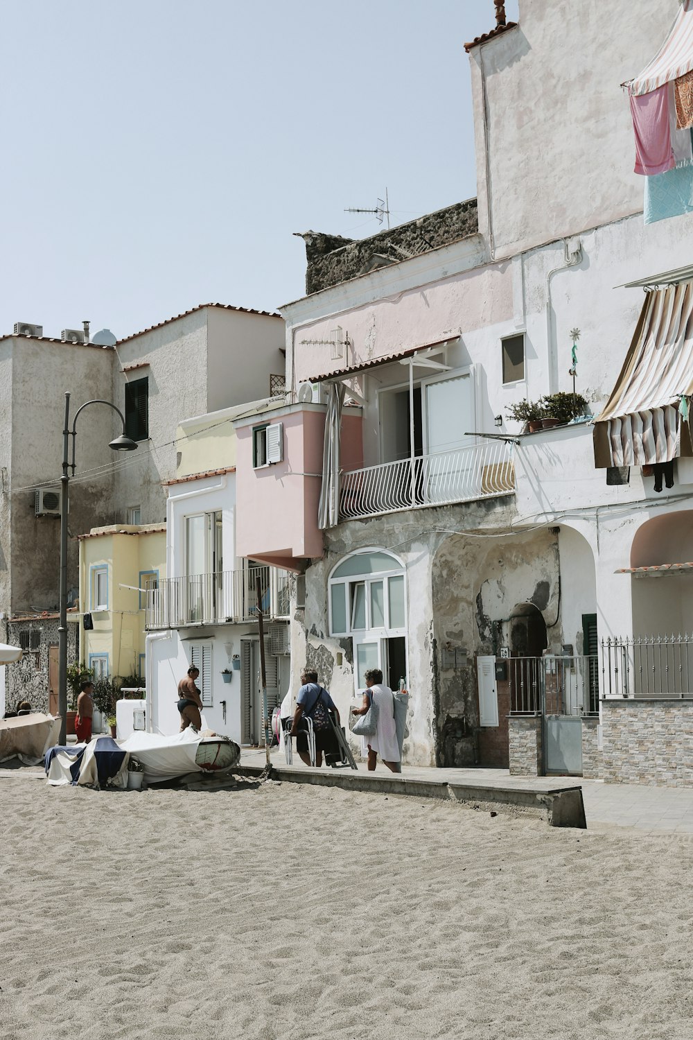 a group of people standing on a beach next to a building