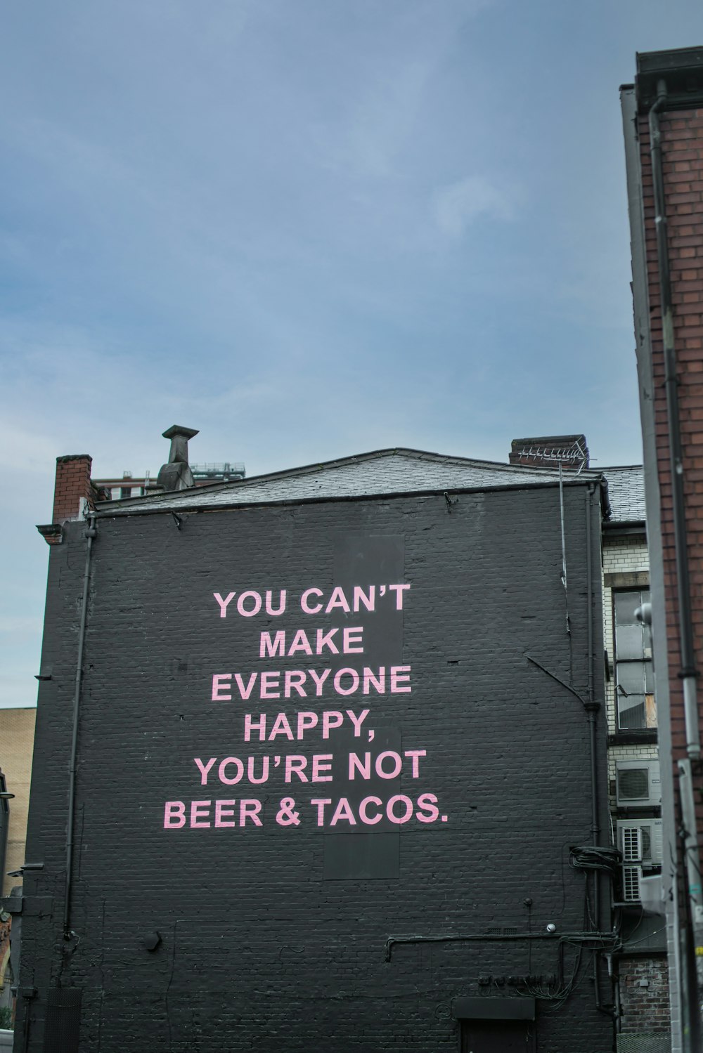 a black building with a pink message on it