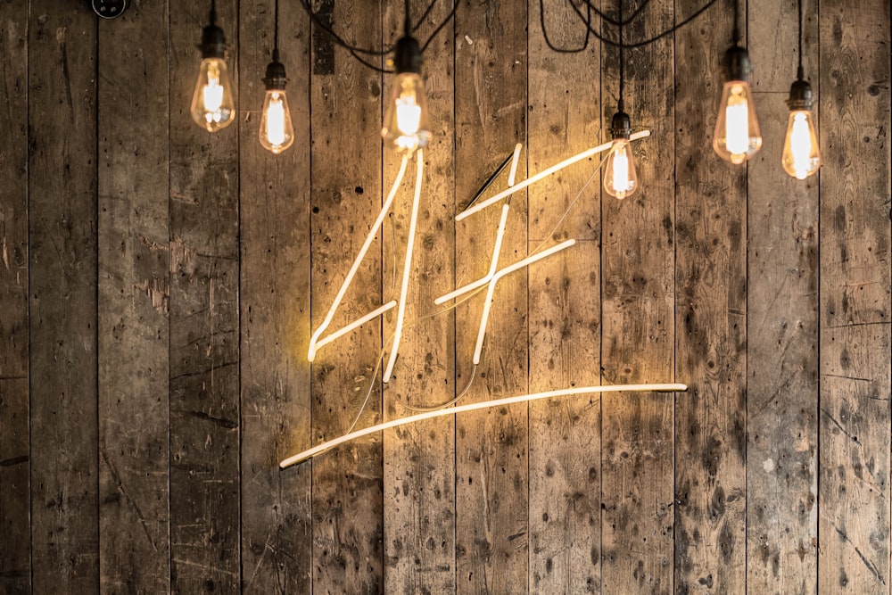 a wooden wall with a neon sign on it