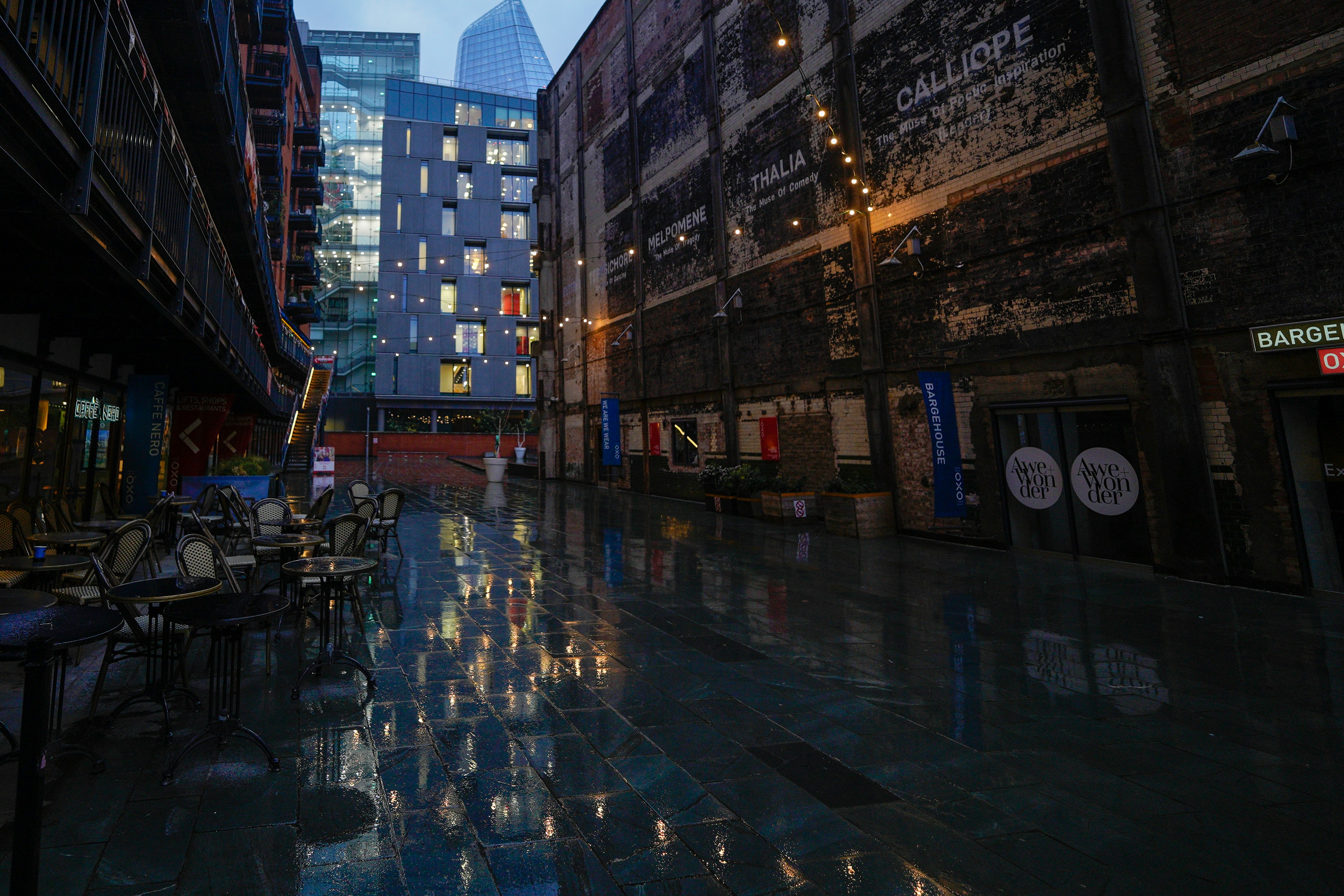 Rain-soaked street with sunlight breaking through clouds, puddles reflecting light, calm hopeful mood