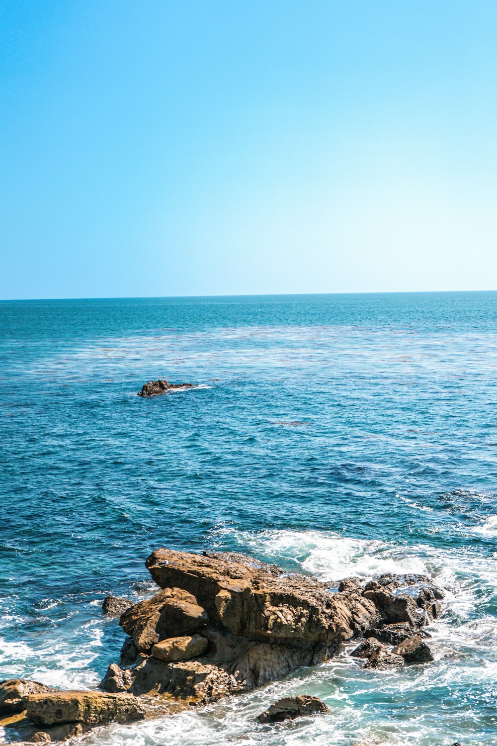 a large body of water sitting next to a rocky shore